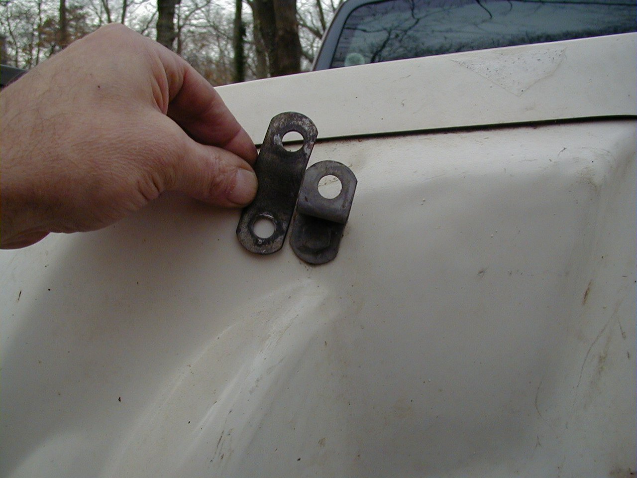 DB saddlebag upper rear bracket that attaches to an existing hole in the frame. Loop bracket is being held by Charley; Tonti bracket is secured to the saddlebag.