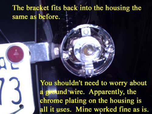 The bracket fits back into the housing the same as before. You shouldn't need to worry about a ground wire. Apparently, the chrome plating on the housing is all it uses. Mine worked fine as is.