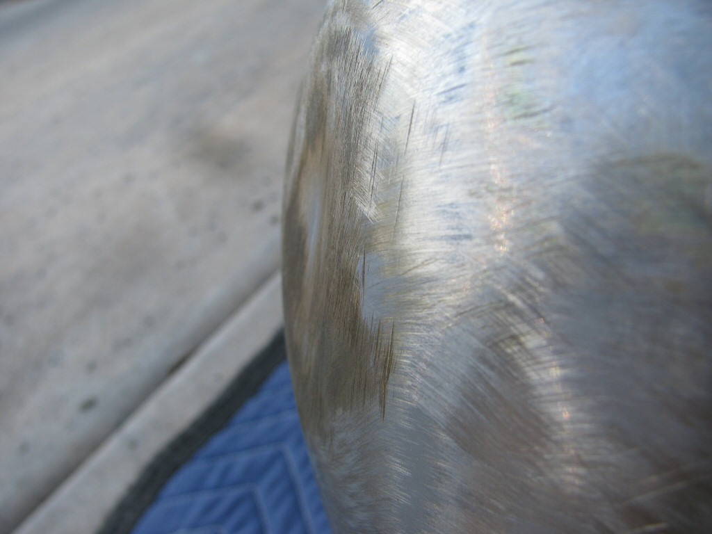 Gas tank stripped of paint. Same dent on left side of tank.